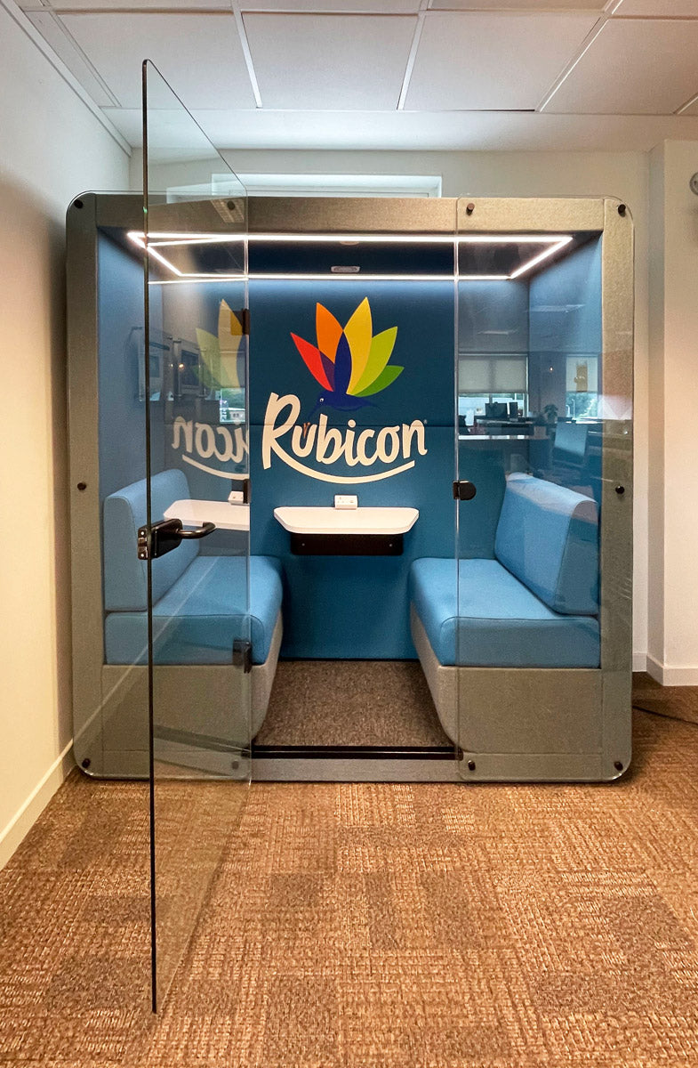 4 person meeting pod with a glass door and custom branding printed inside
