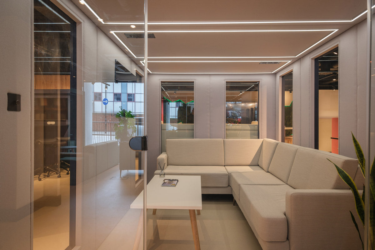 A meeting room size meeting pod with soft seating inside