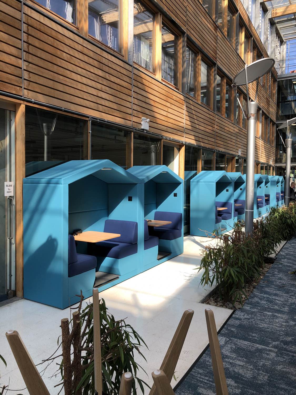 jdd 2 seat open front bea meeting pods. a row of 8 bea meeting pods in blue fabric in a university.