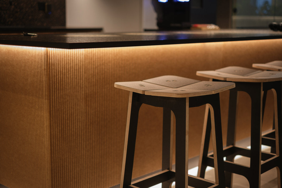 wooden stools with angled tops sat at a kitchen worktop
