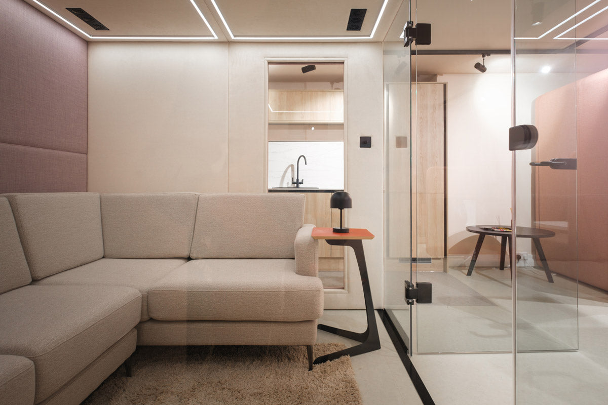 A meeting pod with a corner sofa and laptop table inside