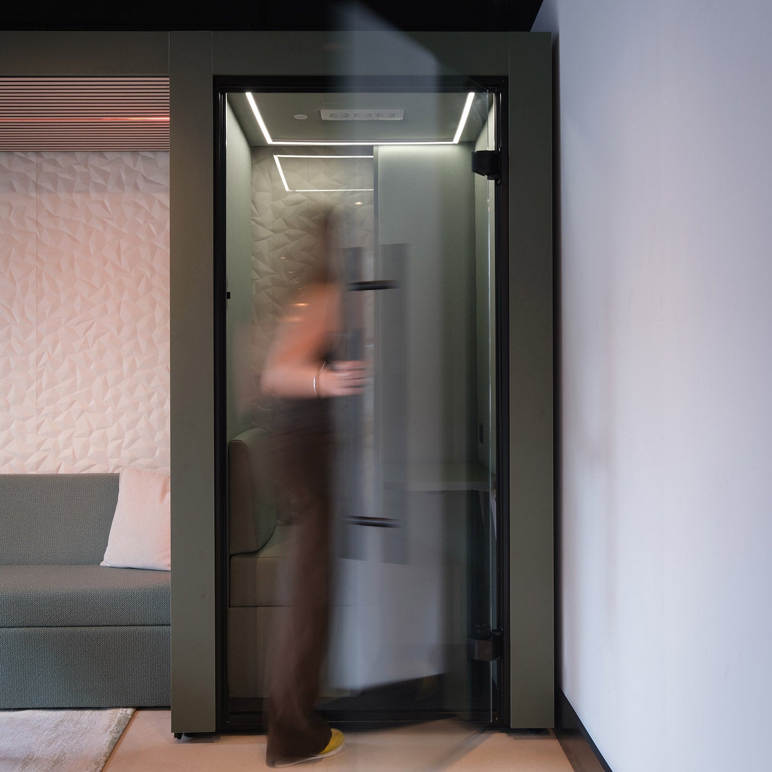 a lady opening the door to the clara acoustic meeting pod and entering to take a phone call