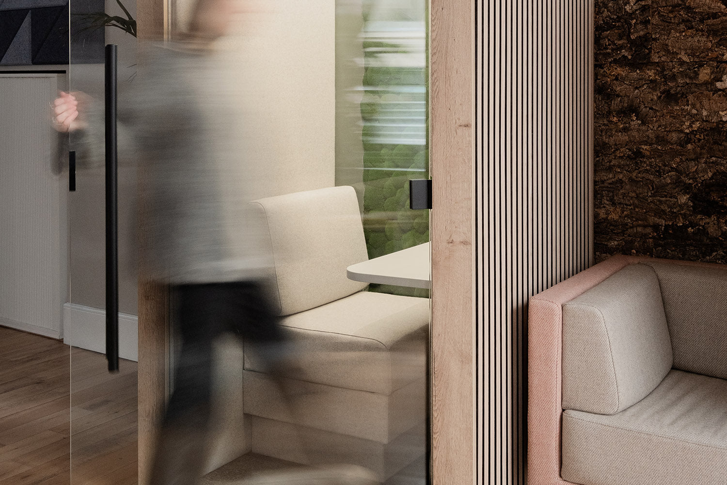 a woman opening the glass door to walk inside the jdd clara meeting pod