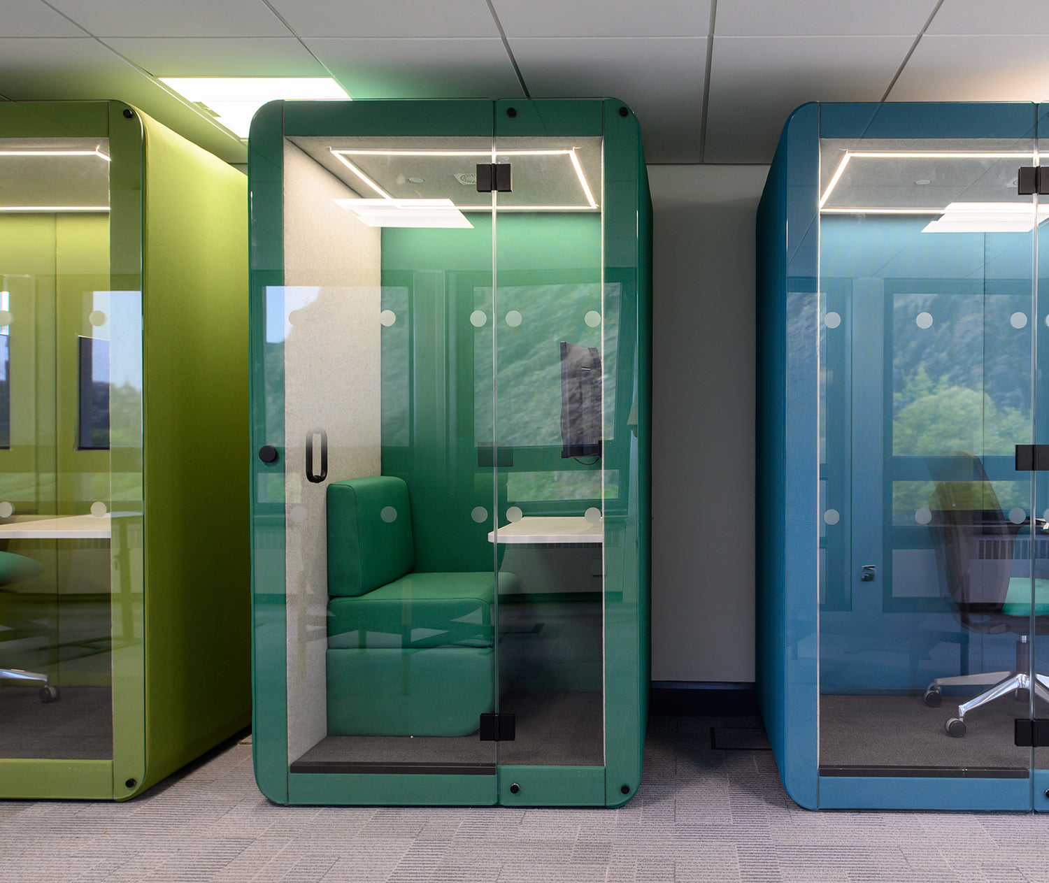 a row of jdd penelope workbooth meeting pods in green and blue